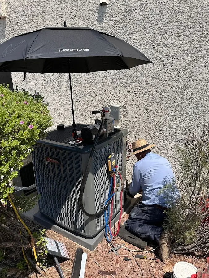 HVAC technician performing outdoor AC maintenance in Kaysville